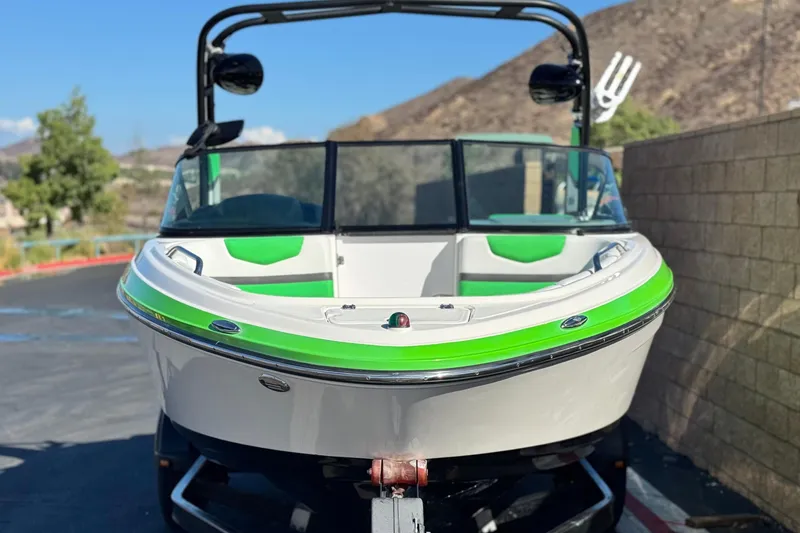 Slide: The Image of 2015 Chaparral Vortex 203 VRX boat with green accents, parked outdoors. - 2