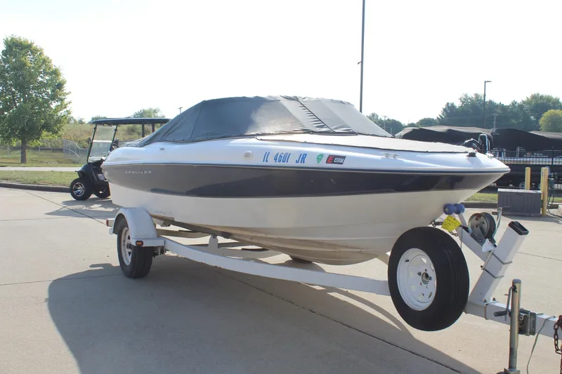 Slide: The Image of 2002 Bayliner 1950 Capri Classic boat on trailer, covered and parked outdoors. - 11