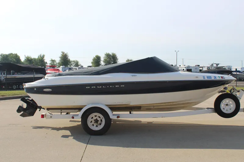 Slide: The Image of 2002 Bayliner 1950 Capri Classic boat on trailer, covered and parked outdoors. - 12