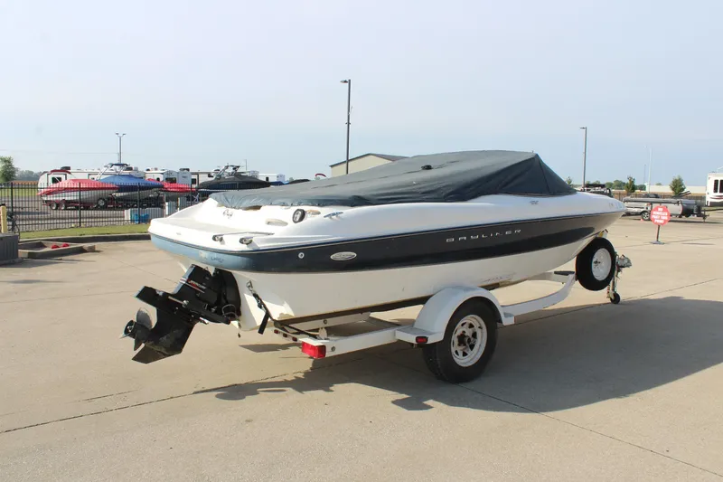 Slide: The Image of 2002 Bayliner 1950 Capri Classic boat on trailer, covered and parked outdoors. - 13