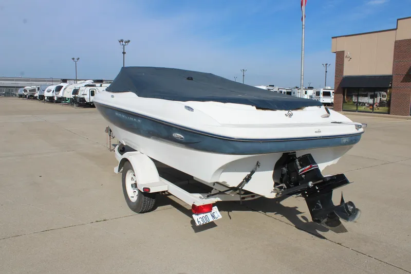 Slide: The Image of 2002 Bayliner 1950 Capri Classic boat on trailer, covered, parked in lot. - 15