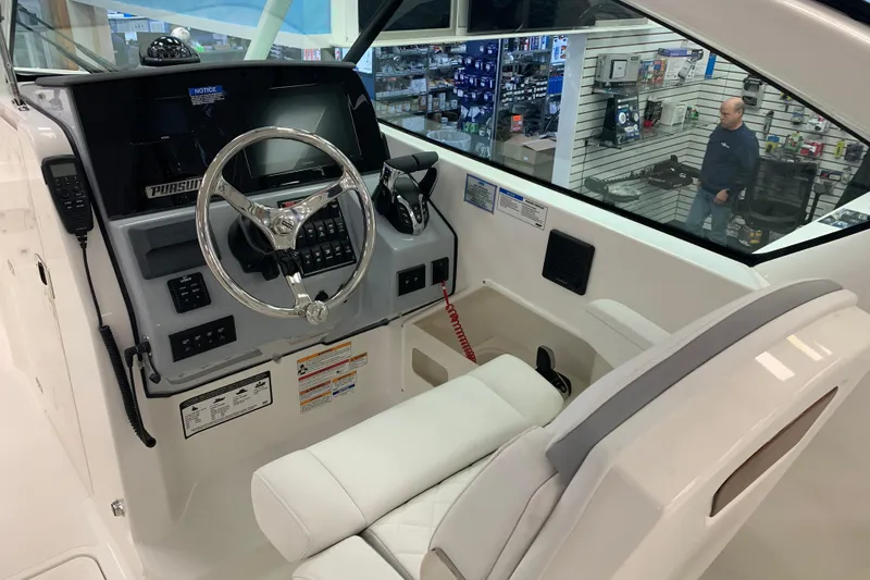 Slide: The Image of 2025 Pursuit DC 266 Dual Console boat interior with steering wheel and control panel. - 11