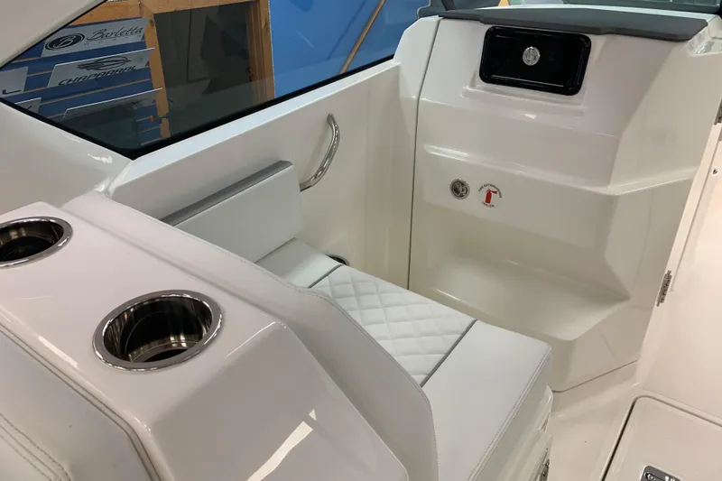 Slide: The Image of 2025 Pursuit DC 266 Dual Console interior with white seating and cup holders. - 12