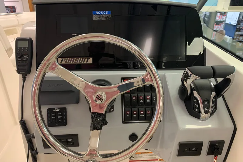 Slide: The Image of 2025 Pursuit DC 266 Dual Console boat dashboard with steering wheel and controls. - 14