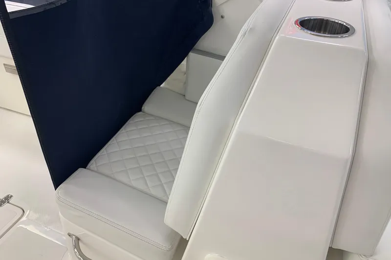 Slide: The Image of 2025 Pursuit DC 266 Dual Console boat interior with white seating and cup holders. - 16