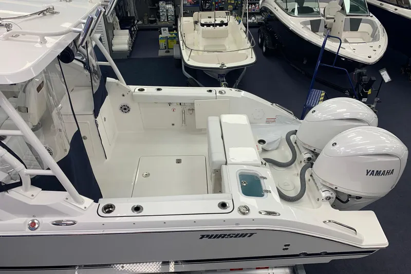 Slide: The Image of 2025 Pursuit DC 266 Dual Console boat with Yamaha engines in showroom. - 2