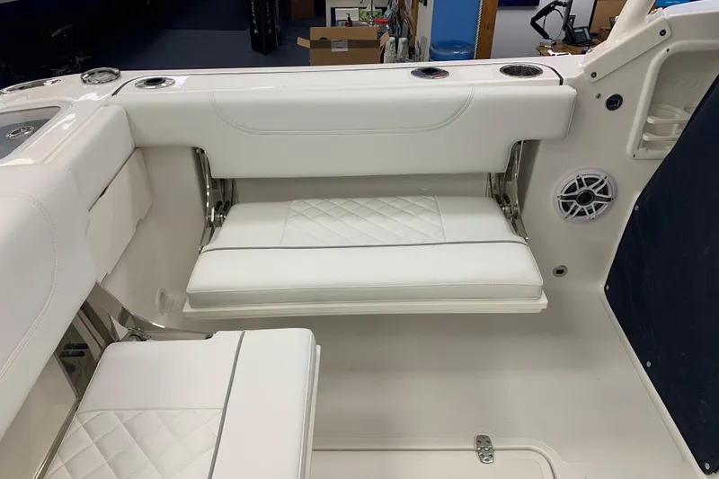 Slide: The Image of 2025 Pursuit DC 266 Dual Console boat interior with white cushioned seating and cup holders. - 27