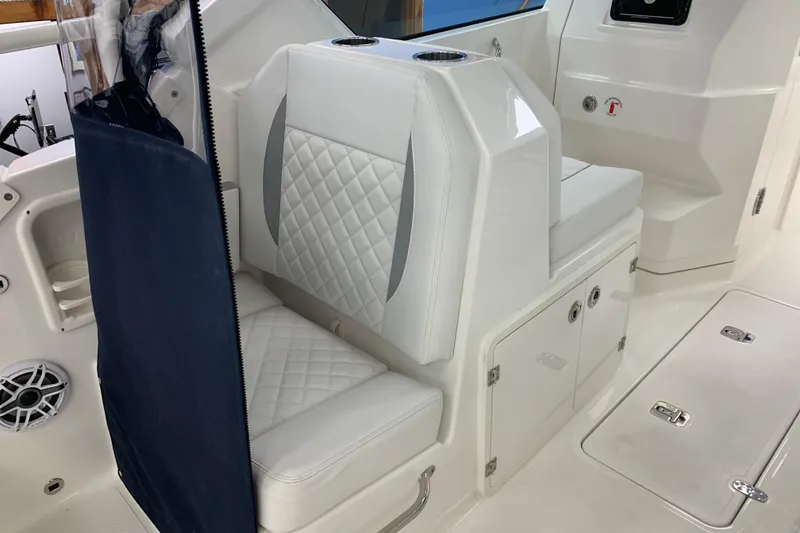 Slide: The Image of 2025 Pursuit DC 266 Dual Console interior with white seating and storage compartments. - 29