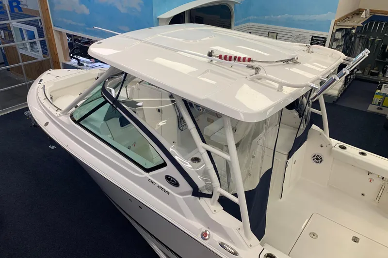 Slide: The Image of 2025 Pursuit DC 266 Dual Console boat in showroom, featuring sleek design and spacious interior. - 3