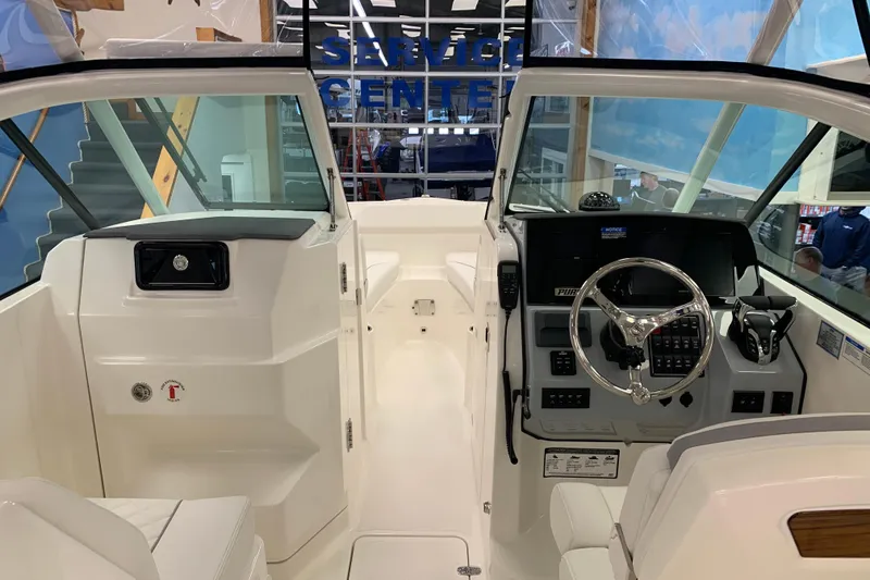 Slide: The Image of 2025 Pursuit DC 266 Dual Console boat interior with modern dashboard and steering wheel. - 30