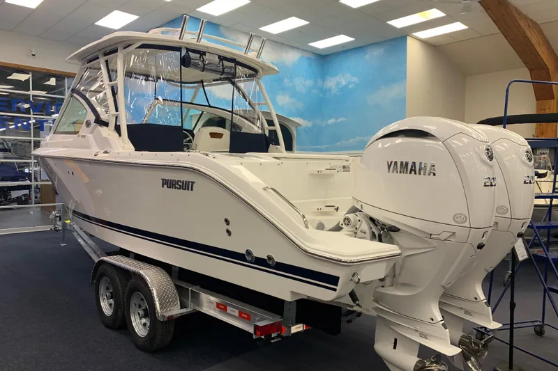 Slide: The Image of 2025 Pursuit DC 266 Dual Console boat with Yamaha engines on display indoors. - 6