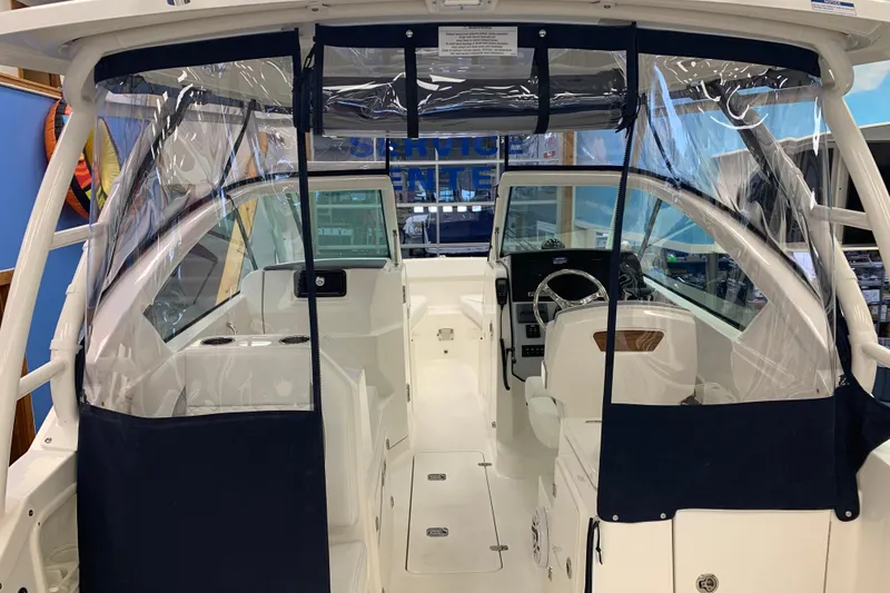 Slide: The Image of 2025 Pursuit DC 266 Dual Console boat interior with clear protective covers. - 9