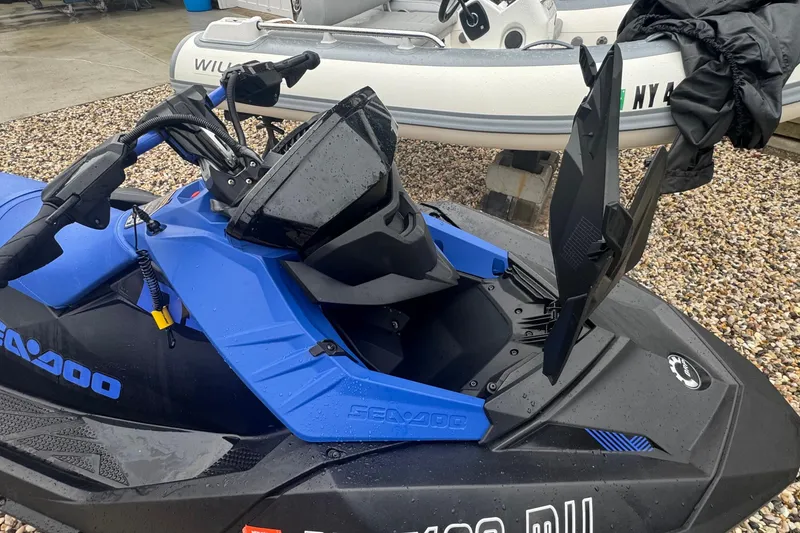 Slide: The Image of 2023 Sea-Doo Spark Trixx jet ski with open storage compartment, blue and black design. - 11