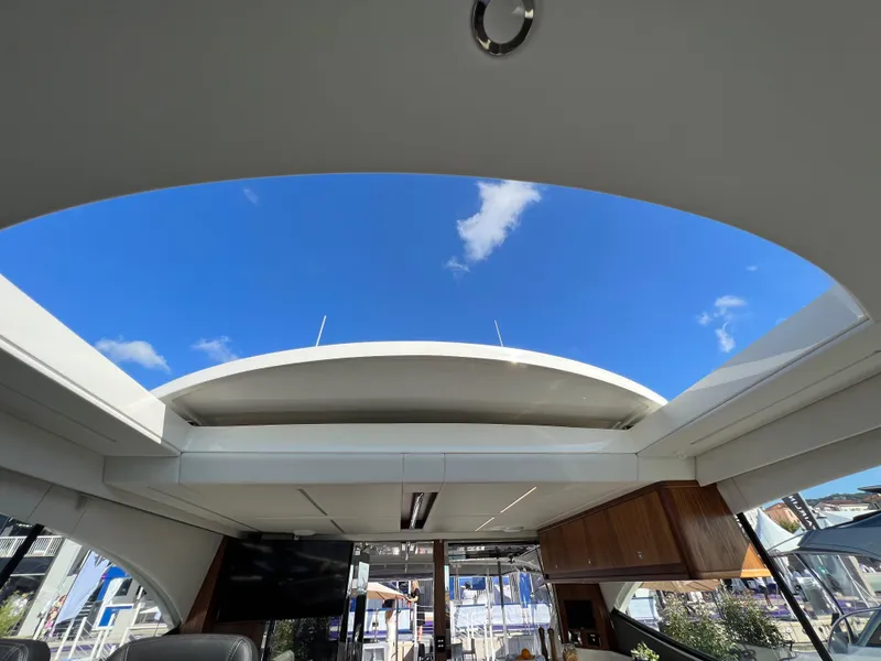 Slide: The Image of Interior view of 2022 Riviera 505 SUV yacht with open sunroof and blue sky. - 29