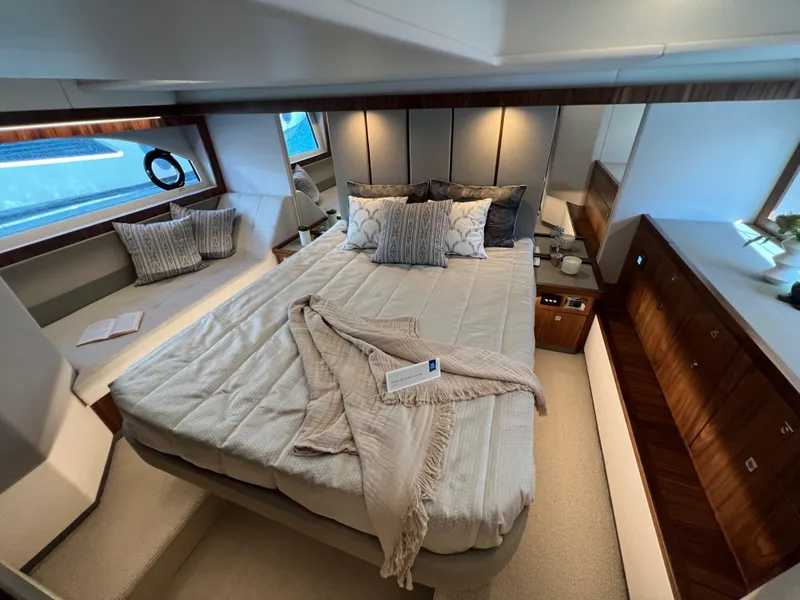 Slide: The Image of Luxurious bedroom interior of 2022 Riviera 505 SUV yacht with elegant bedding and wood accents. - 37