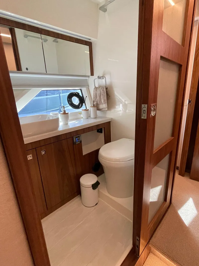 Slide: The Image of Luxurious bathroom in 2022 Riviera 505 SUV yacht with modern fixtures and wooden accents. - 43