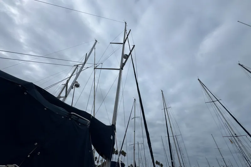 Slide: The Image of Sailboat masts against cloudy sky, featuring 1999 Hunter Passage 420. - 11