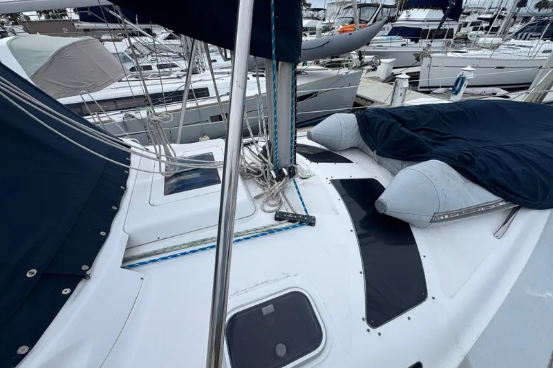 Slide: The Image of 1999 Hunter Passage 420 sailboat deck with ropes and covered equipment in marina. - 12
