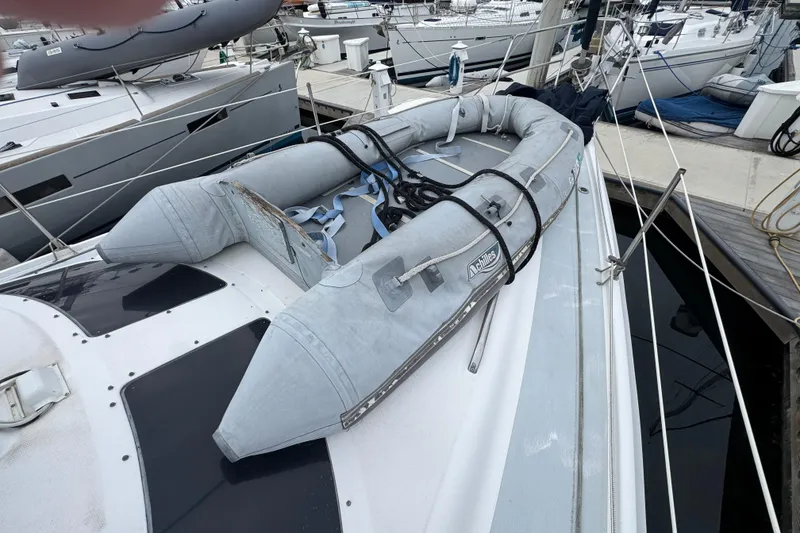 Slide: The Image of 1999 Hunter Passage 420 sailboat with inflatable dinghy on deck at marina. - 13