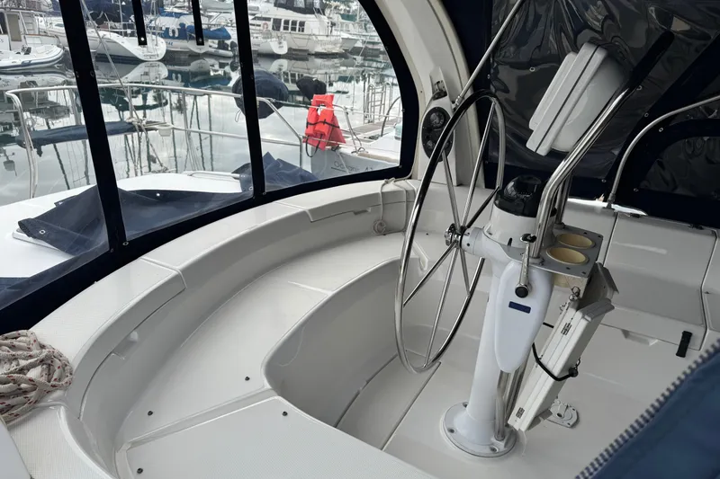Slide: The Image of Cockpit of 1999 Hunter Passage 420 sailboat with steering wheel and marina view. - 17