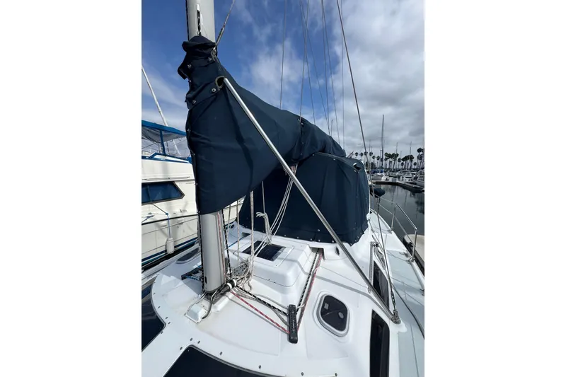 Slide: The Image of 1999 Hunter Passage 420 sailboat with covered mast, docked in marina. - 2