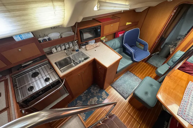 Slide: The Image of Interior of 1999 Hunter Passage 420 yacht with kitchen and seating area. - 29