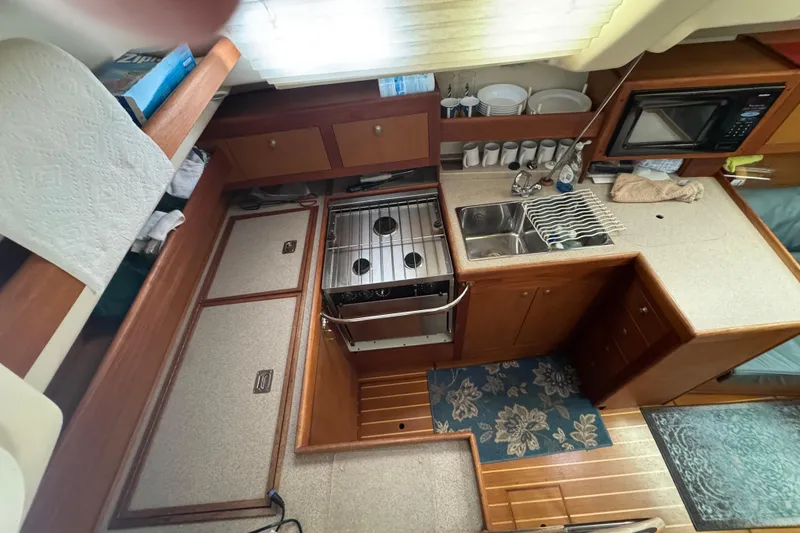 Slide: The Image of 1999 Hunter Passage 420 yacht kitchen with stove, sink, and microwave. - 30