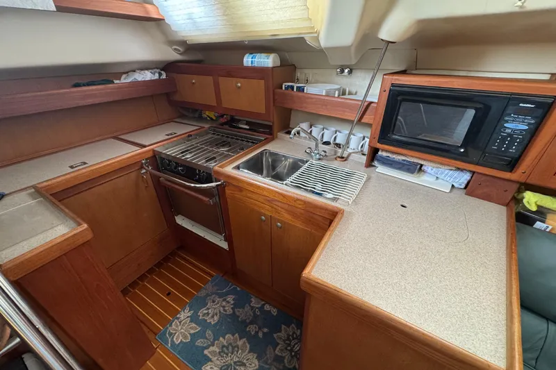 Slide: The Image of 1999 Hunter Passage 420 yacht kitchen with stove, sink, and microwave. - 33