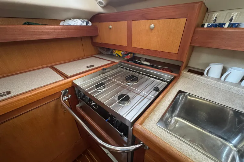 Slide: The Image of 1999 Hunter Passage 420 yacht kitchen with stove, sink, and wooden cabinetry. - 36