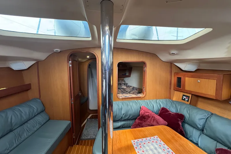 Slide: The Image of Cozy interior of 1999 Hunter Passage 420 sailboat with skylights and seating area. - 42