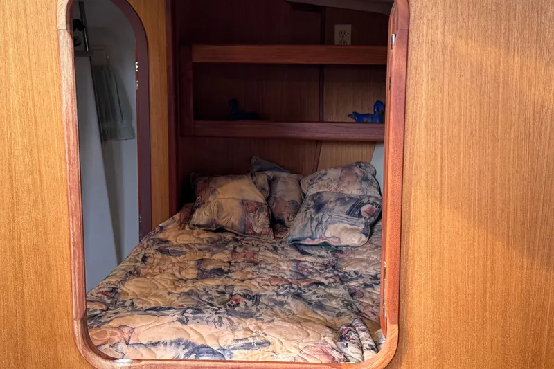 Slide: The Image of Cozy cabin interior of 1999 Hunter Passage 420 sailboat with patterned bedding. - 43