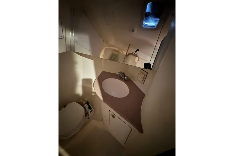 Slide: The Image of 1999 Hunter Passage 420 yacht bathroom with sink, mirror, and toilet. - 48
