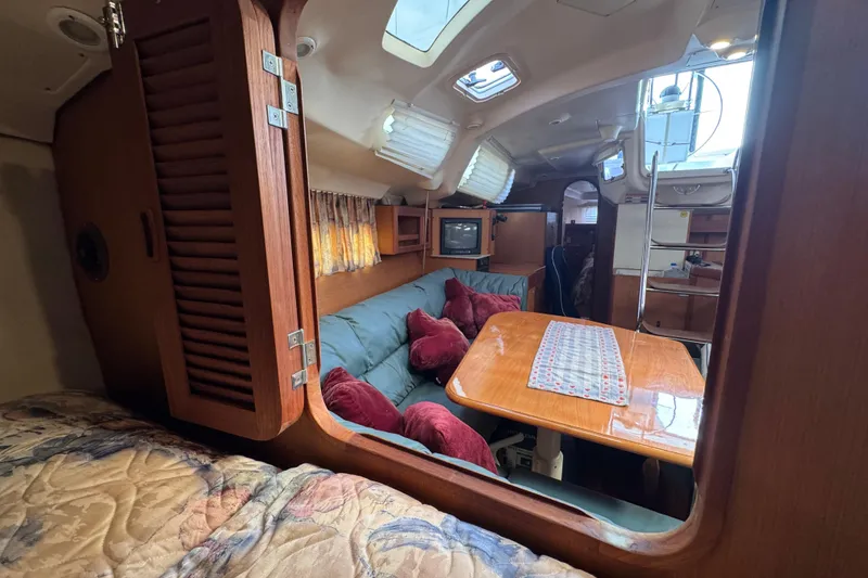 Slide: The Image of Cozy interior of 1999 Hunter Passage 420 sailboat with wood finishes and seating area. - 49