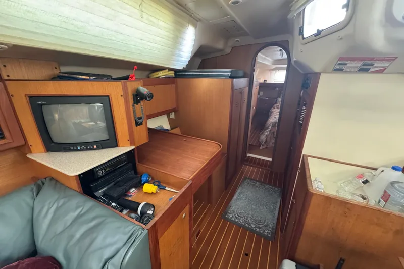 Slide: The Image of Interior of 1999 Hunter Passage 420 sailboat with TV, storage, and cozy cabin space. - 50