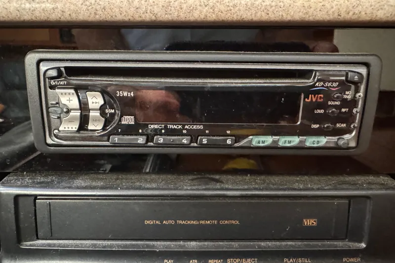 Slide: The Image of Vintage JVC car stereo and VHS player in a 1999 Hunter Passage 420. - 56