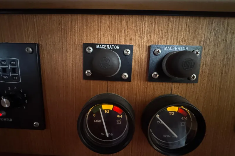 Slide: The Image of Control panel of a 1999 Hunter Passage 420 yacht with macerator switches and tank gauges. - 59