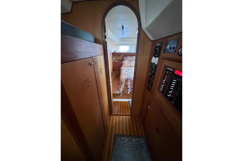 Slide: The Image of Interior view of 1999 Hunter Passage 420 sailboat, featuring wood paneling and cozy cabin. - 63