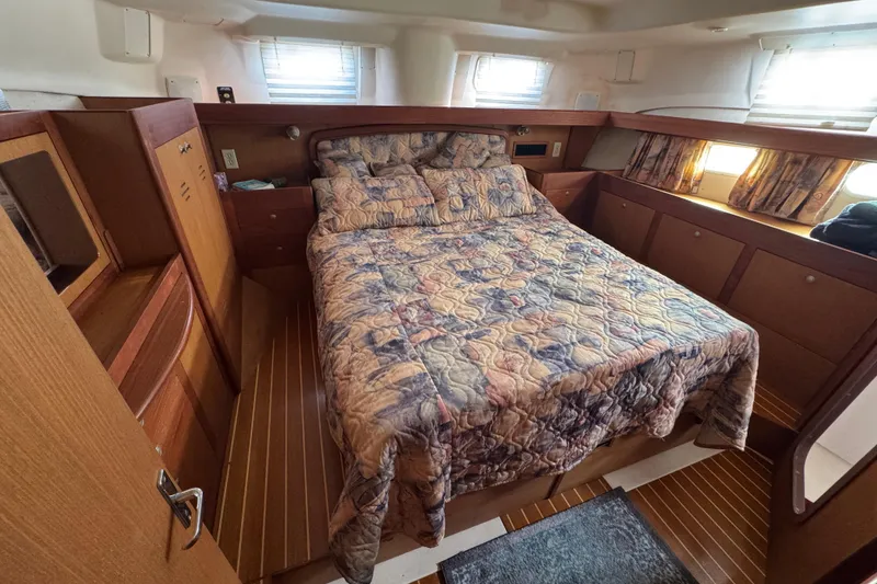Slide: The Image of Cozy cabin interior of 1999 Hunter Passage 420 sailboat with bed and wooden furnishings. - 64