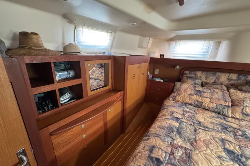 Slide: The Image of Cozy cabin interior of 1999 Hunter Passage 420 sailboat with wooden storage and bed. - 65