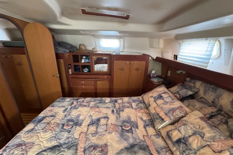 Slide: The Image of Cozy cabin interior of 1999 Hunter Passage 420 yacht with bed and wooden storage. - 73