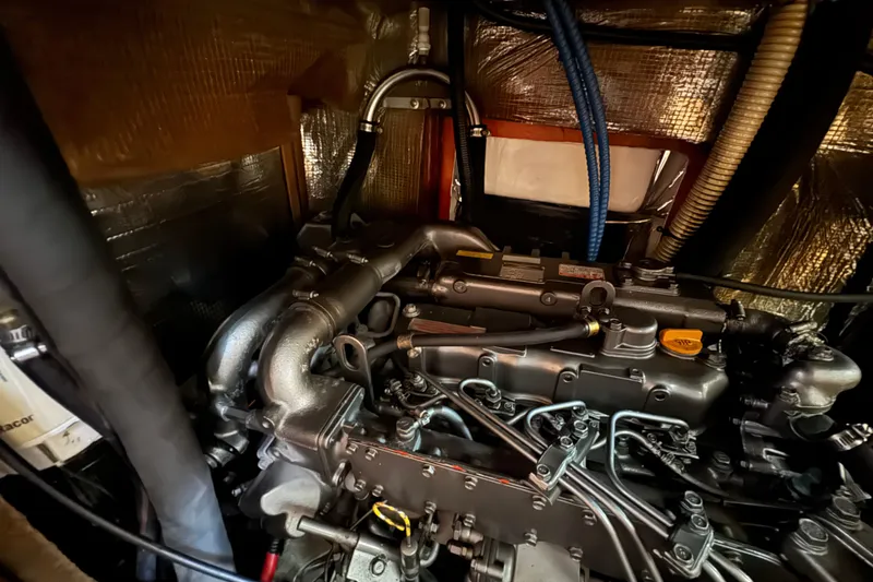 Slide: The Image of Engine compartment of a 1999 Hunter Passage 420 sailboat, showcasing detailed components. - 77