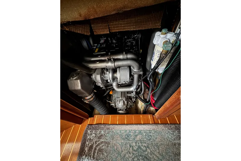 Slide: The Image of Engine compartment of a 1999 Hunter Passage 420 sailboat, showing detailed mechanical components. - 80