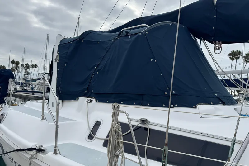 Slide: The Image of 1999 Hunter Passage 420 sailboat with blue canvas cover docked at marina. - 9