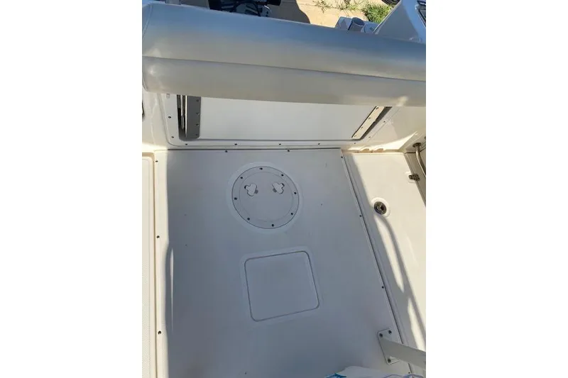 Slide: The Image of 2021 Boston Whaler 230 Outrage deck view with seating and storage compartments. - 19
