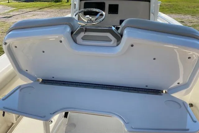 Slide: The Image of 2021 Boston Whaler 230 Outrage boat console with steering wheel and storage compartment. - 25