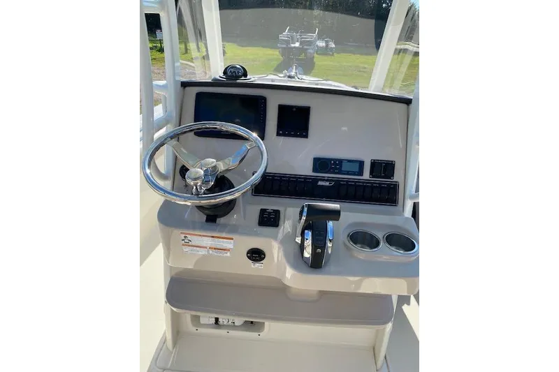 Slide: The Image of 2021 Boston Whaler 230 Outrage helm with steering wheel, controls, and navigation screens. - 31