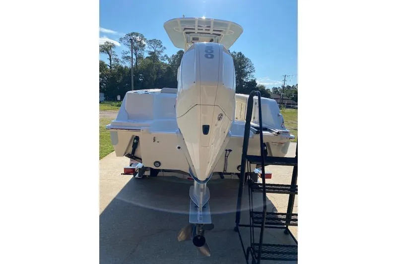 Slide: The Image of 2021 Boston Whaler 230 Outrage boat, rear view with outboard motor, parked outdoors. - 38