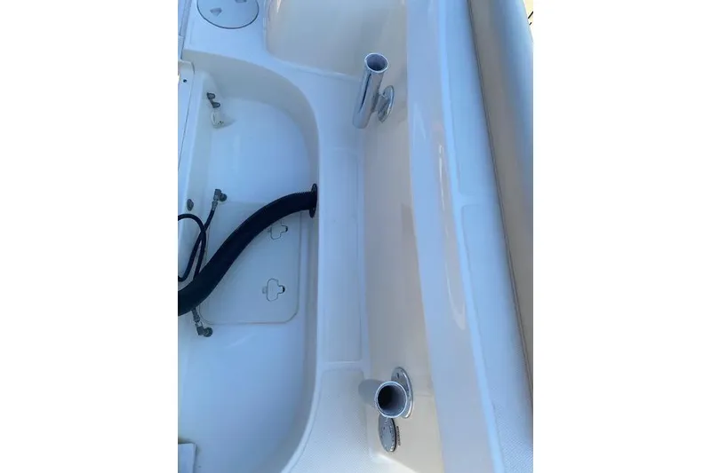 Slide: The Image of 2021 Boston Whaler 230 Outrage boat interior with rod holders and storage compartments. - 7