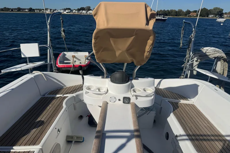 Slide: The Image of 1998 Beneteau Oceanis 352 sailboat cockpit with wooden deck and covered helm, docked on calm water. - 11