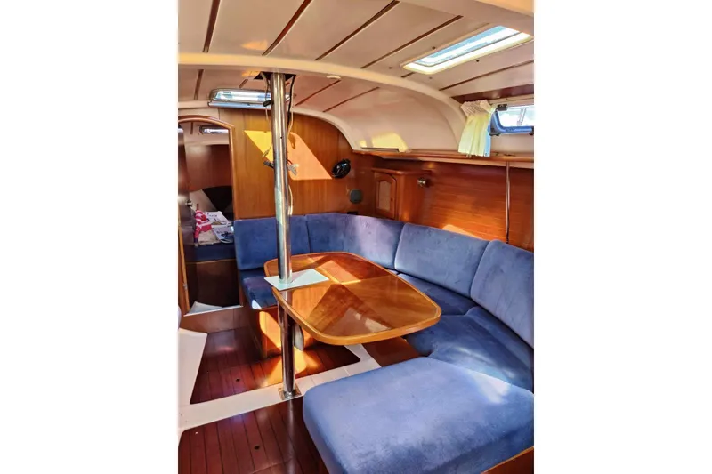 Slide: The Image of Interior of 1998 Beneteau Oceanis 352 sailboat with blue seating and wooden table. - 16